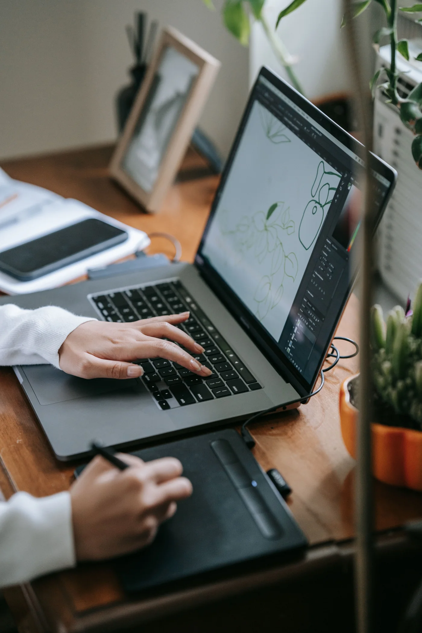 Digital creative workspace with a laptop and drawing tablet