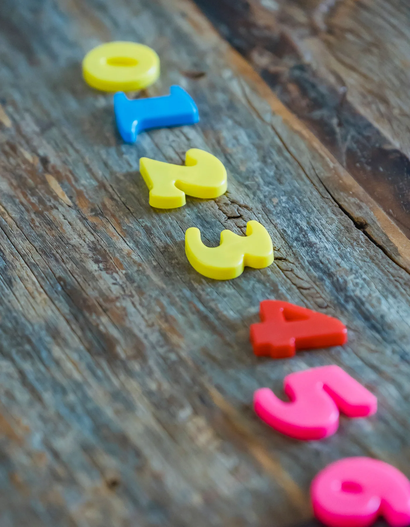 Colorful toy numbers arranged on a wooden table